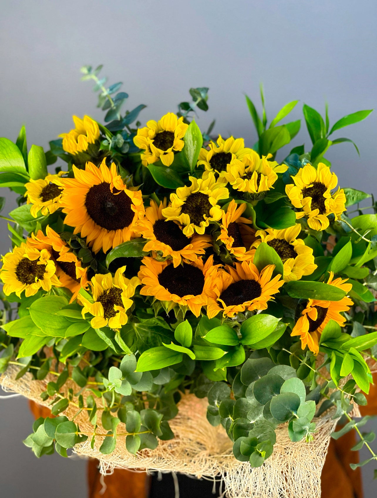 Sevdiklerinize pozitif bir enerji göndermek için mükemmel bir seçim: Sunshine Joy Ayçiçeği Buketi. 17 adet sarı ayçiçeği ve doğal yeşilliklerle hazırlanan bu canlı aranjman, özel günleriniz için ideal bir hediye. Hızlı teslimat ve premium çiçeklerle Eser Çiçekçilik'ten.