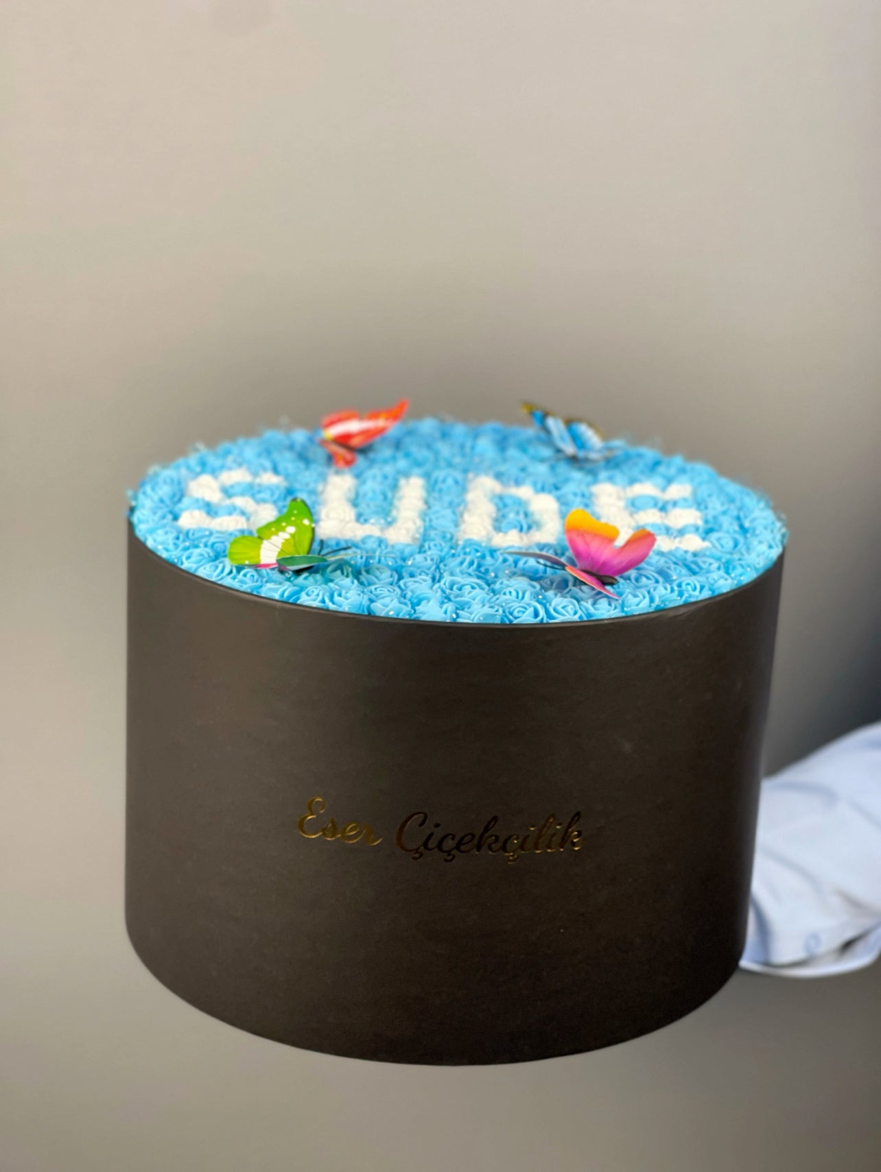 Siyah silindir kutu içerisinde lateks güllerin üstten görünümü