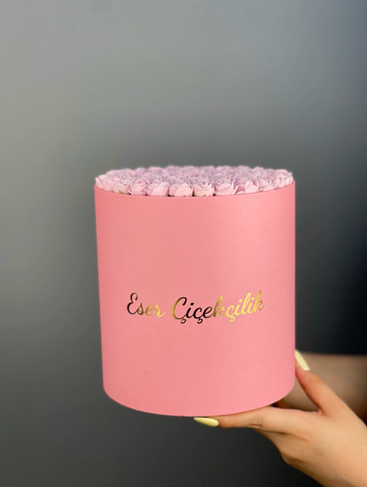 Genel görünüm: 17×18 cm pembe silindir kutuda, önden çekimde pembe güllerin düzenli kompozisyonu ve kutu dokusu.