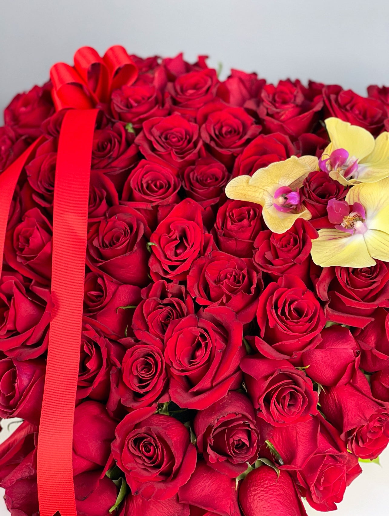 Infinite Heart aranjmanı, kalp şeklinde düzenlenmiş 70-80 kırmızı gül ve 3 orkide kandiliyle etkileyici bir hediye seçeneği.