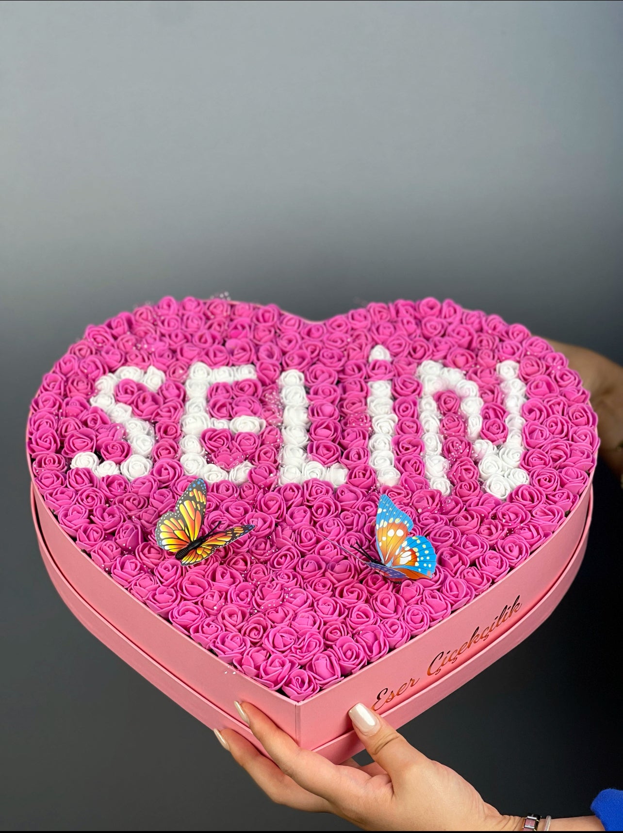 Üstten bakışta 37 cm pembe kalp kutuda fuşya ve beyaz güllerle yapılmış isim tasarım düzeni