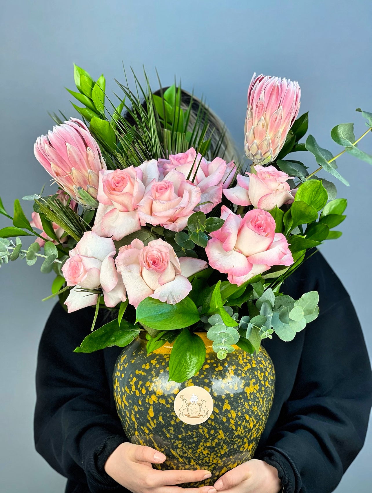 Modern vazo tasarımı ile aranjmanın sofistike düzenlemesi ve estetik sunumu vurgulanıyor.