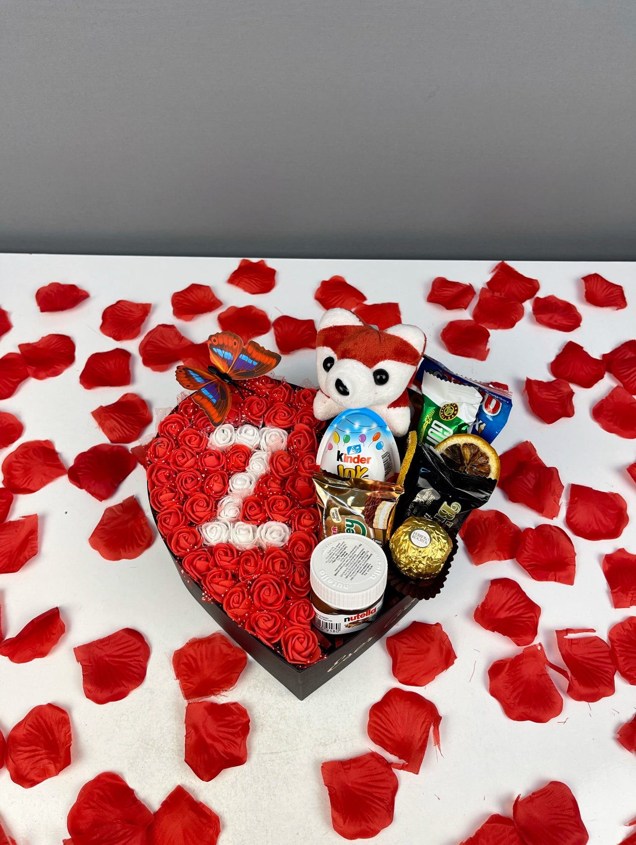 Yandan görünüm: siyah kutuda güller, çikolatalar ve peluş oyuncak detaylı sunum