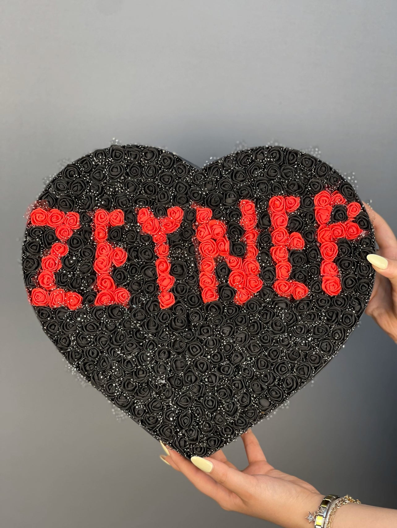 Üstten bakışta 37 cm siyah kutuda siyah lateks güller ve kırmızı isim tasarımın zarif düzeni
