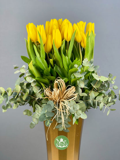 Modern iç mekan dekorasyonuna enerji katan Deluxe Golden Bloom Arrangement, canlı sarı lalelerle öne çıkıyor.