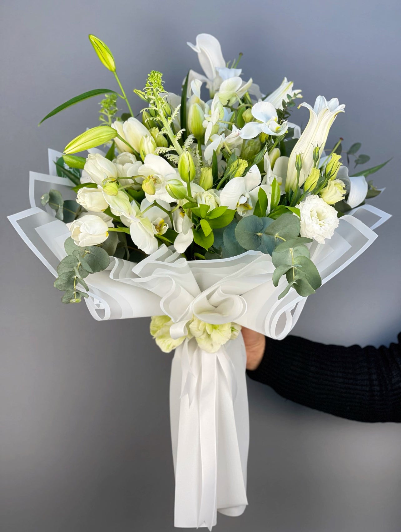 3 dal lilium, 13 beyaz lale, 2 beyaz lahana çiçeği, 1 demet beyaz lisyantus ve 3 dal beyaz orkidenin oluşturduğu opulent white enchantment buketi.