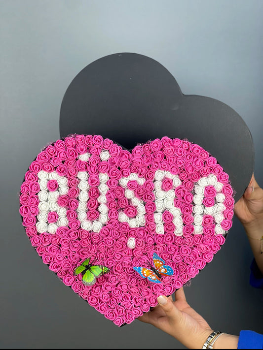 Grande boy siyah kalp kutuda fuşya güller üzerine beyaz güllerden yapılmış isim tasarımının ön cephe görünümü