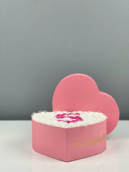 Üstten bakışta 20 cm pembe kalp kutuda beyaz güller ve fuşya harf tasarım
