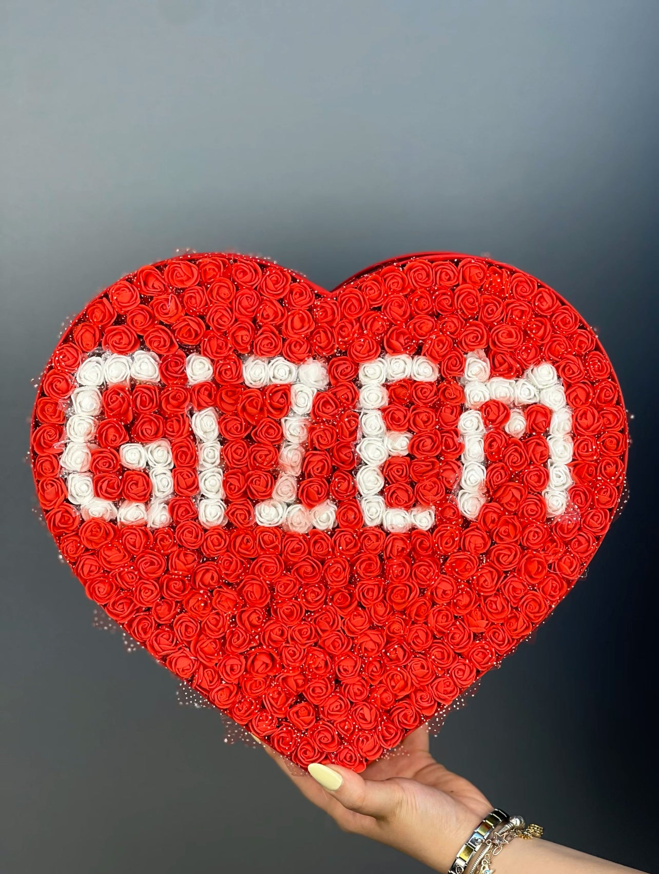 Üstten bakışta 37 cm kırmızı kutuda kırmızı güller ve beyaz isim tasarımın zarif düzeni